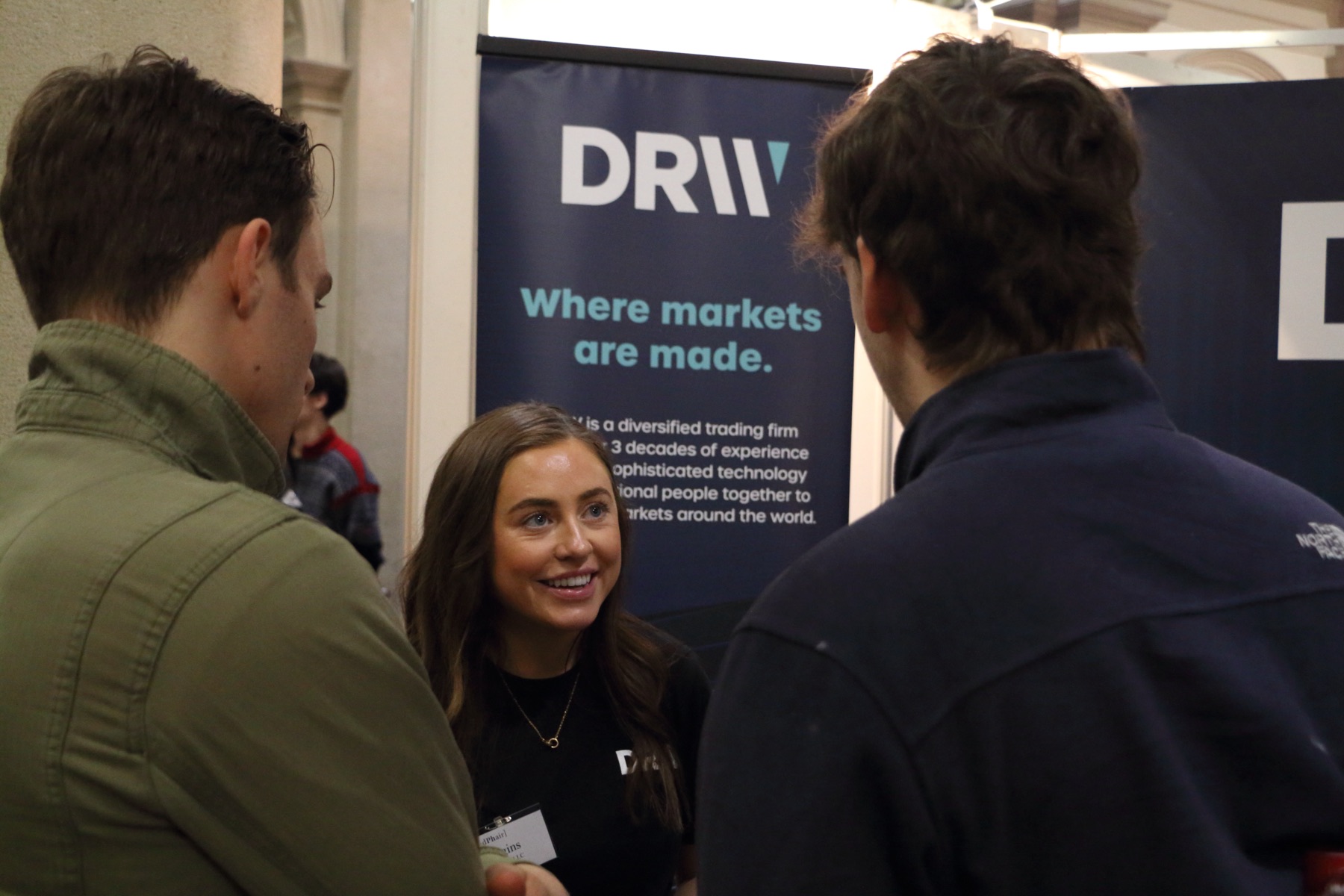 A student laughing with a company representative at the DRW booth, MindPhair 2024
